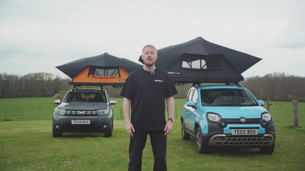 TentBox Lite roof tent open on car in summer UK countryside, two cars parked together with awning attached